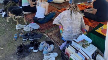Groups of people gathering in the Budapest park for the event "ecofeminist library"