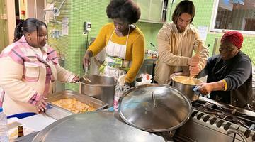 Four women cooking in a friendly and learning environment