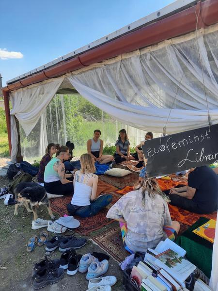 Groups of people gathering in the Budapest park for the event "ecofeminist library"