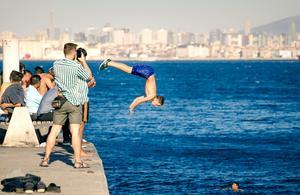 A man wearing blue short diving in daylight A man wearing blue short diving in daylight