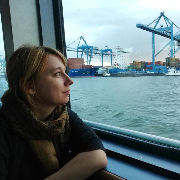 Shipping Elisabeth Schober staring across the water at shipping containers and cranes.